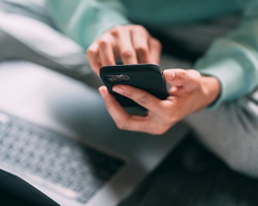 unrecognizable man browsing smartphone on bed